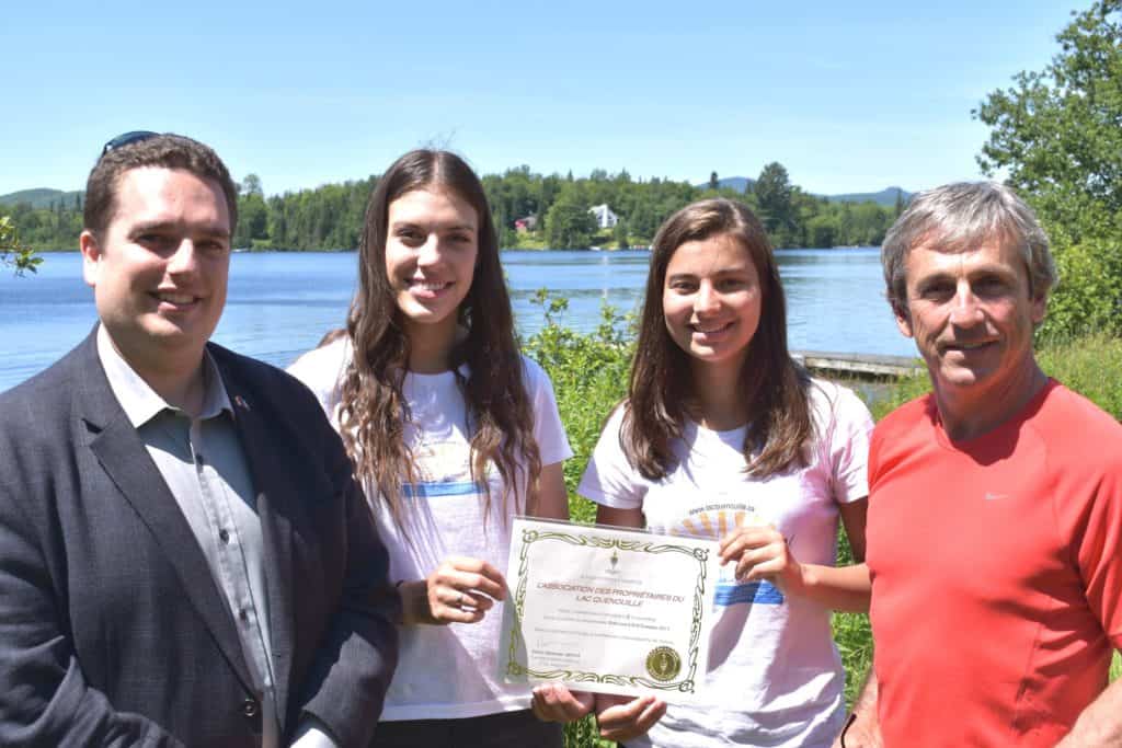 Sur la photo, le député David Graham pose en compagnie d'Érica Lemay et Camille Comtois, de même que Benoît Huet, président de l’Association des propriétaires du lac Quenouille. - Photo gracieuseté