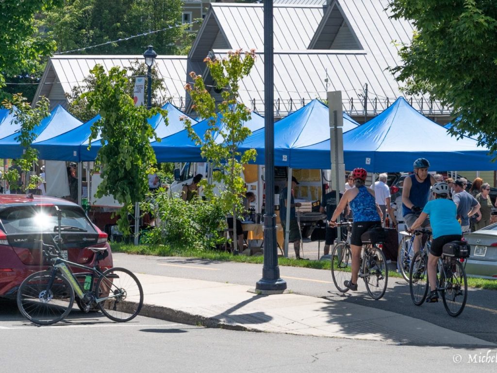 Un marché public à la pace Lagny avec des clients et des gens à vélo