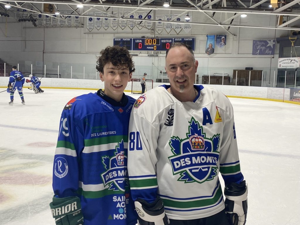un adolescent et son père en tenu de hockey sur la glace