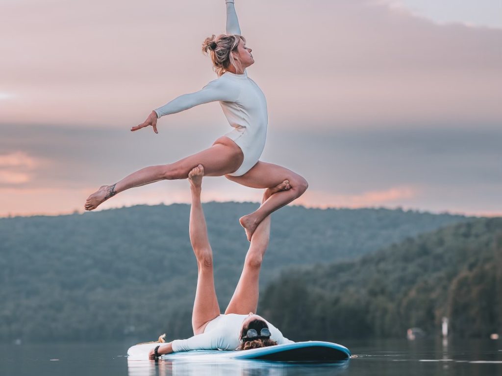 deux femmes font des figures acrobatiques sur un plage dans l'eau