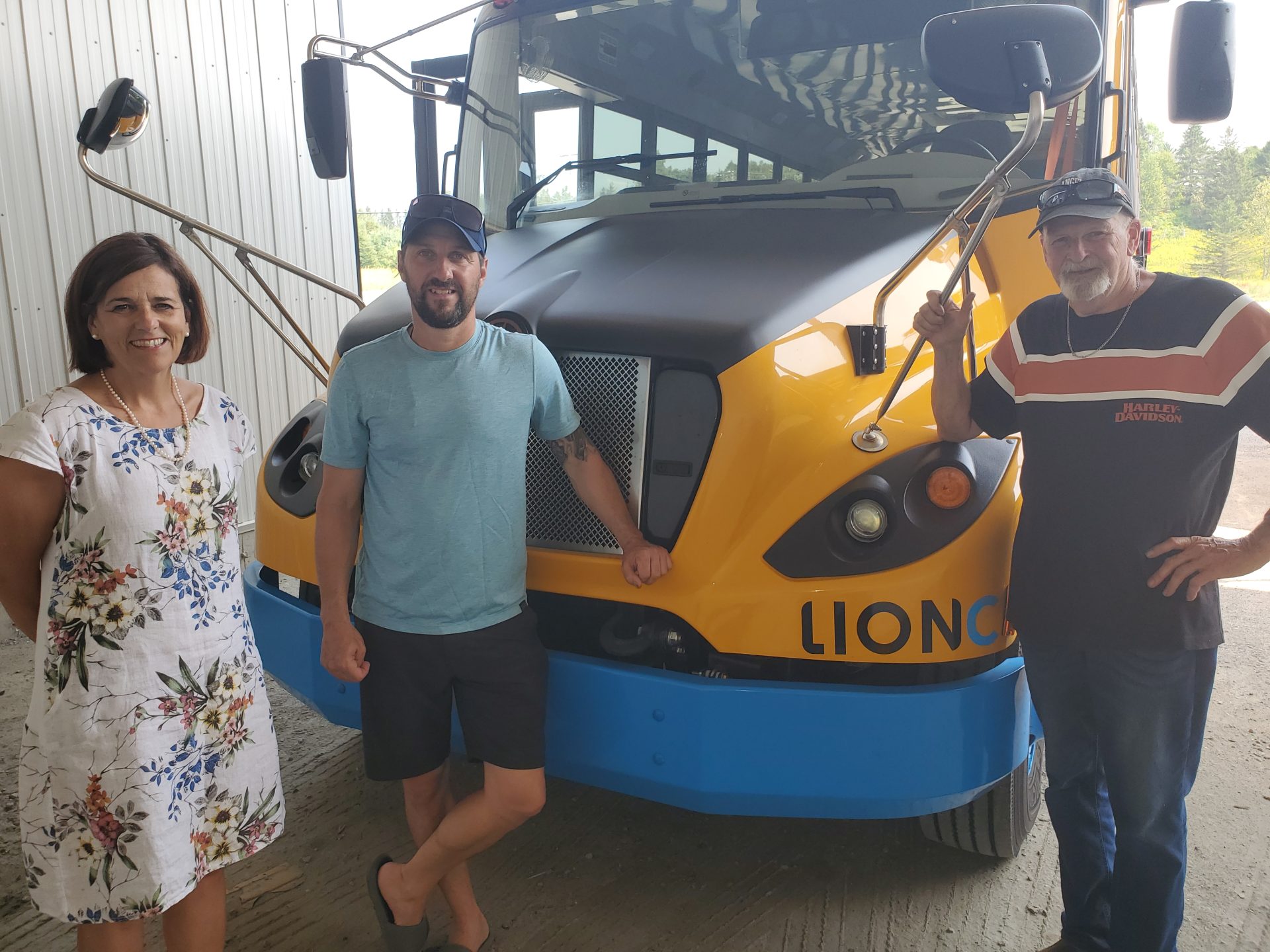 Trois personnes devant un autobus scolaire